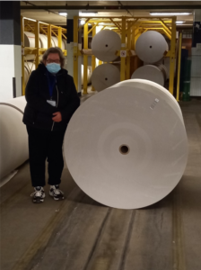 Patricia next to a reel of paper